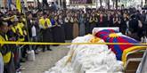 <span style='font-family: Arial; font-size: 15px; color: White;'>Tibetanere holdt til ved siden af en kiste indhyldet i det tibetanske flag med liget af den 27-årige demonstrant Jamphel Yeshi.</span> <span style='font-family: Arial; font-weight: normal; font-size: 15px; color: #999999;'>Foto: Ashwini Bhatia / POLFOTO</span>