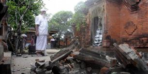 En præst betragter de ødelæggelser, jordskælvet har medført på Bali. Selvom rystelserne var kraftige medførte skælvet ikke den frygtede tsunami.