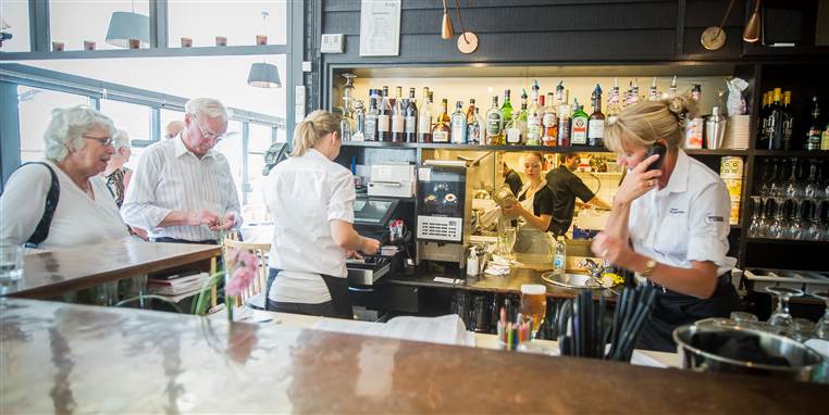 Medarbejderne på Vejlegården serverer for to gæster.