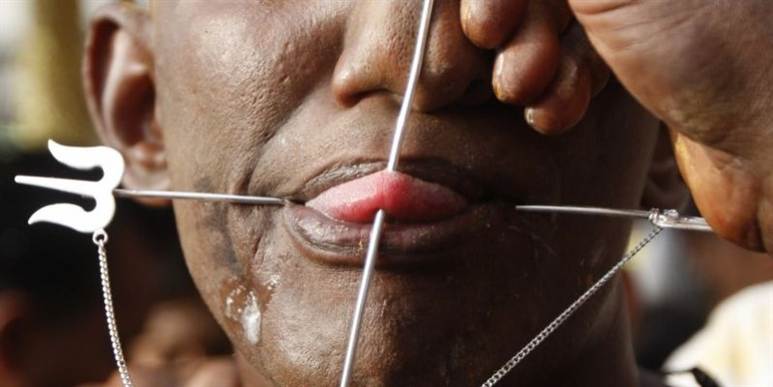 Det ser makabert ud her, hvor en dedikeret hindu-troende pierces i tungen og kinden under Thaipusam-festivalen ved Malaysias hovedstad, Kuala Lumpur.