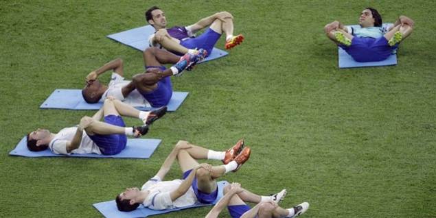 Spillere fra Atletico Madrid strækker ud efter træningen på stadionet i Bukarest.
