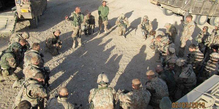 En dansk feltpræst velsigner kampklædte soldater i Afghanistan. Nu vil kirkeminister Manu Sareen (R) have feltpræsterne til at skille kristendom og krig ad.