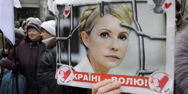 En demonstrant på gaden i byen Kiev holder her et billede op af Yulia Tymoshenko under en støttemarch 28. marts i år.
