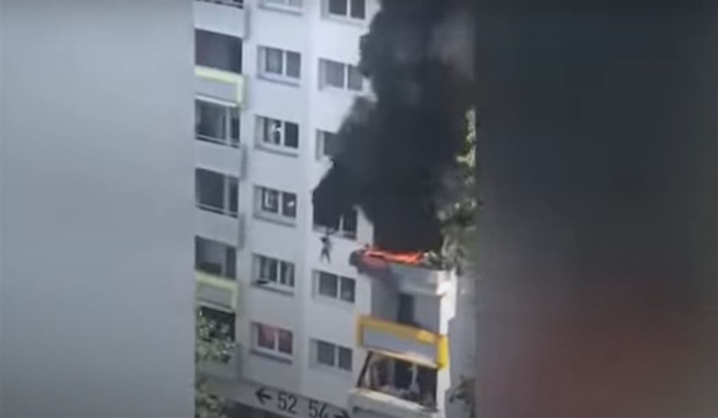 Dreng hænger ud af vinduet i brændende bygning