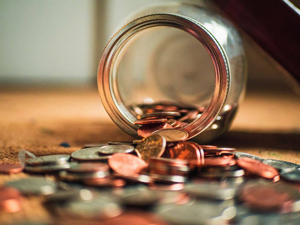 Mønter falder ud af en glaskrukke