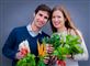Et smilende par med grøntsager i favnen