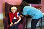 britisk kvinde vaccineres af blåklædt sundhedsmedarbejder