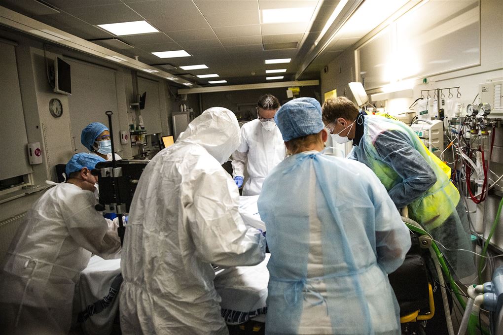 sundhedspersonale står tæt omkring seng på sygehus
