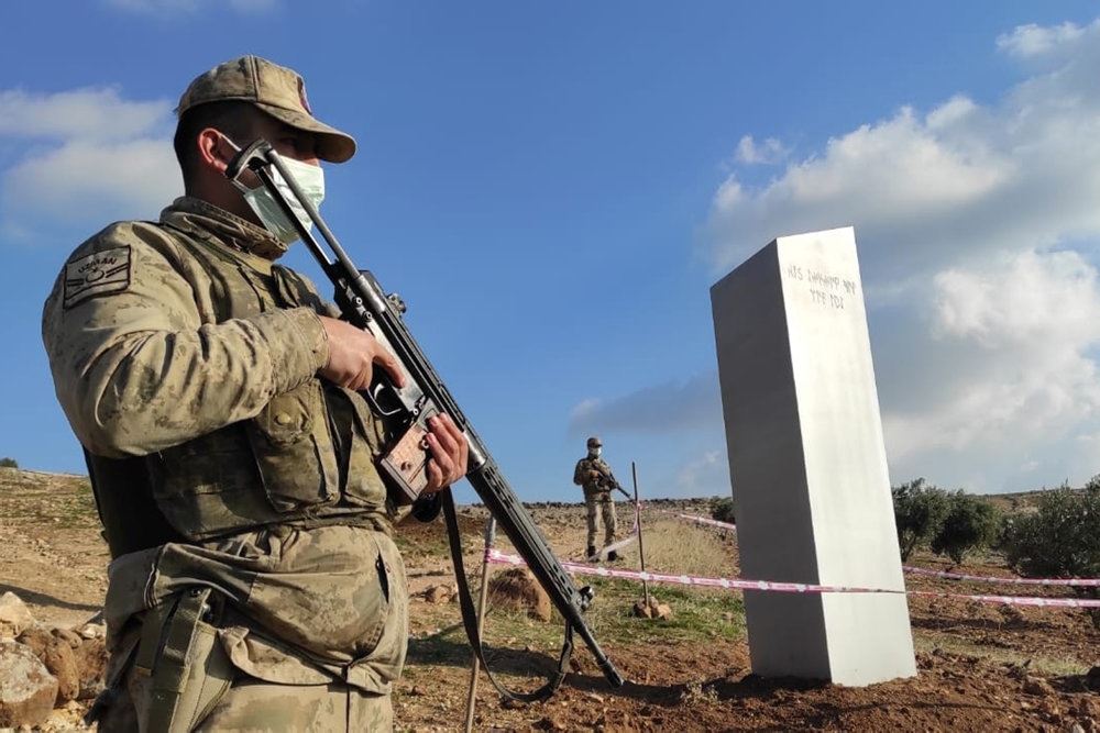 soldat med gevær står ved monolit på en mark