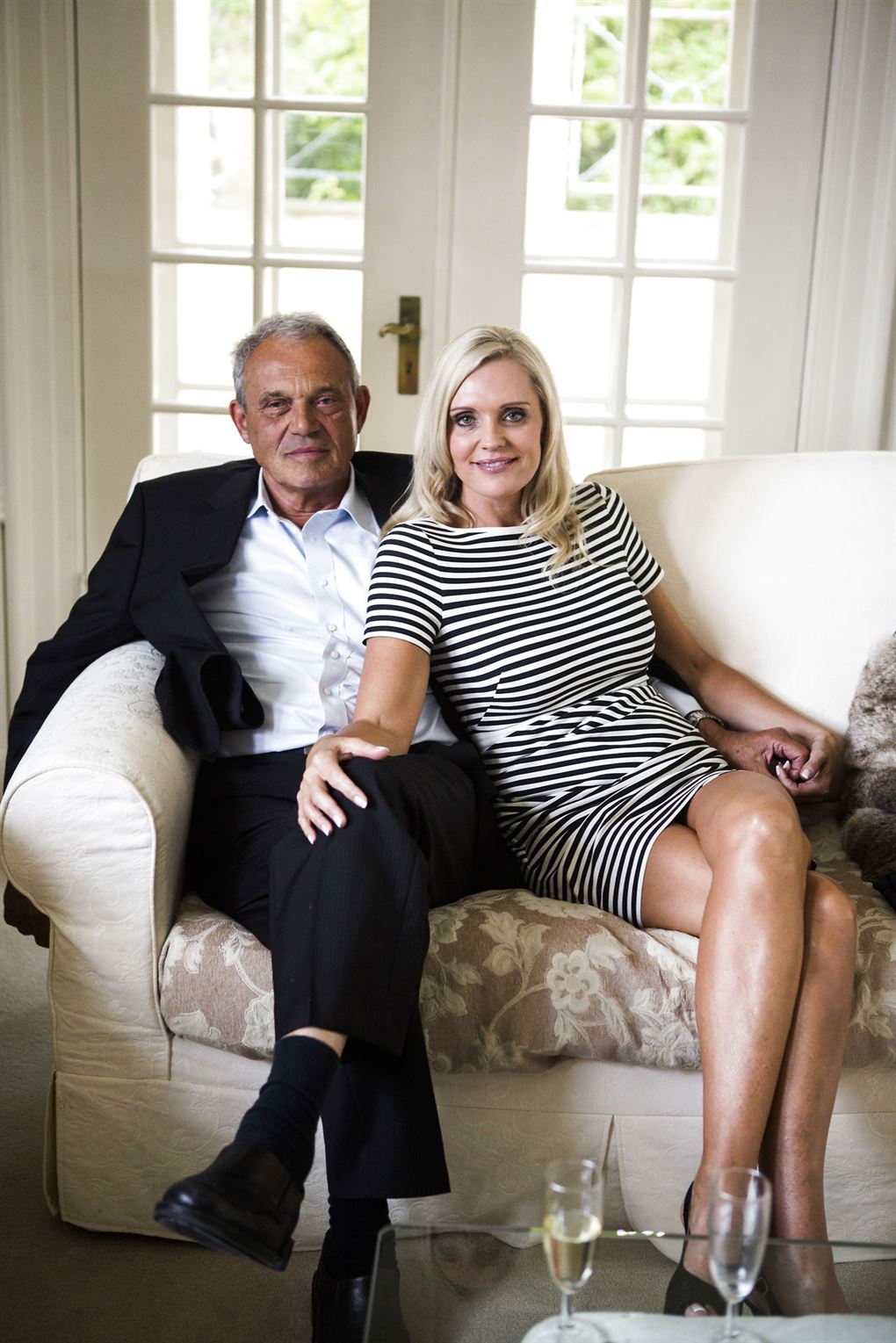 Karsten og Janni Ree i en stor hvid sofa. Hun sidder lidt lænet op mod ham, 