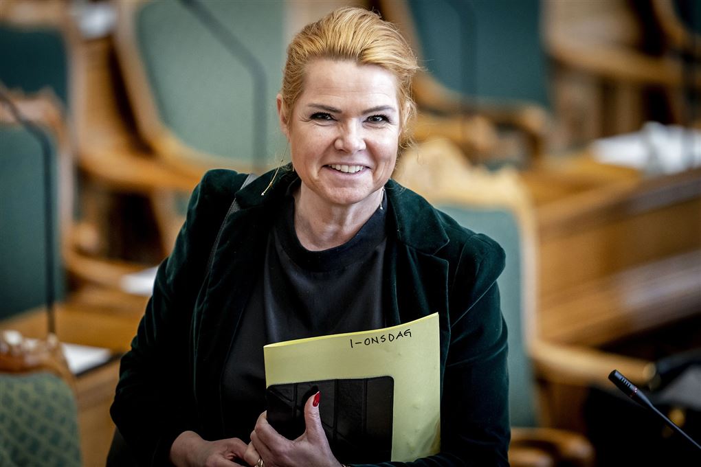 Inger Støjberg i Folketingssalen med et smil til kameraet.