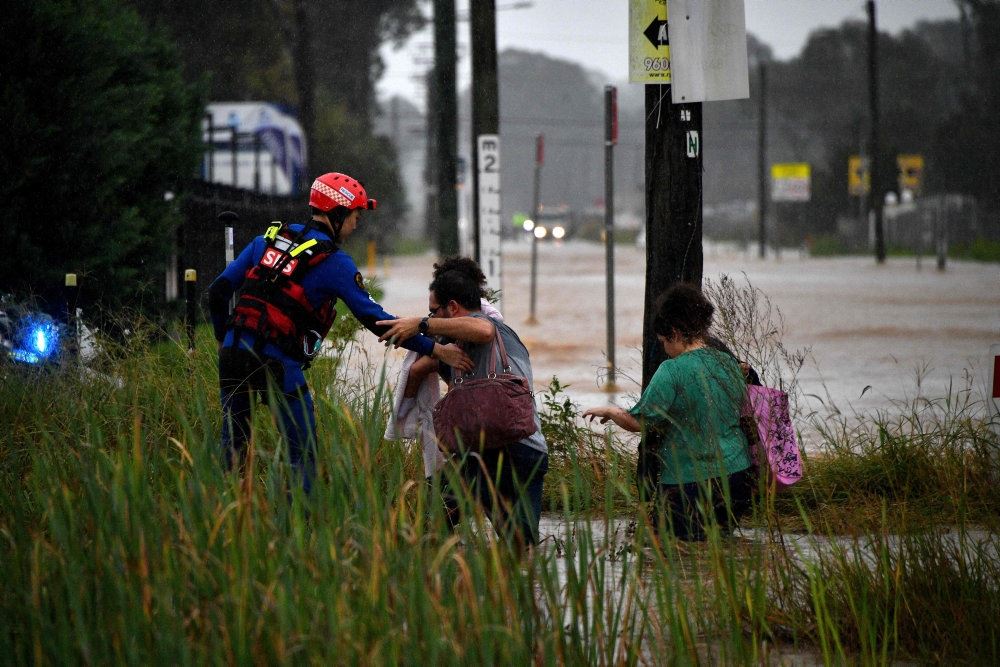 Folk bliver reddet væk fra en oversvømmet vej