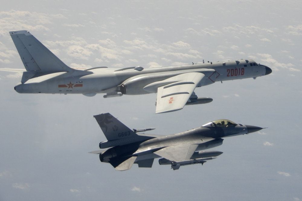 Et F-16 fly og et kinesisk bombefly ved siden af hinanden
