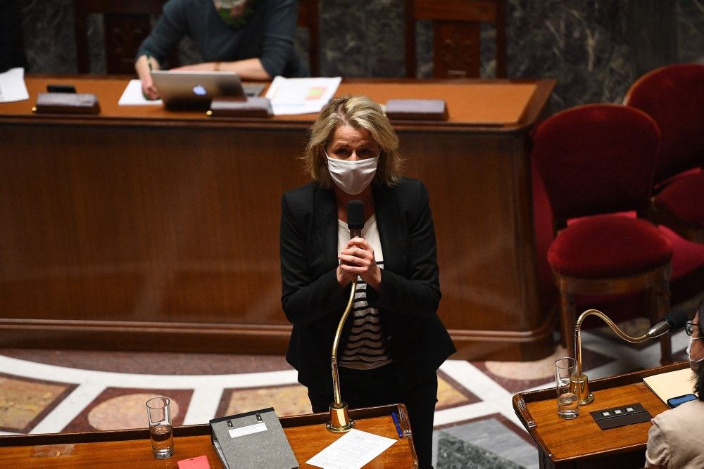 fransk minister med mundbind taler i parlamentet