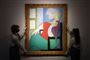 Et farverigt maleri af Picasso holdes i hver sin ramme af to kvinder