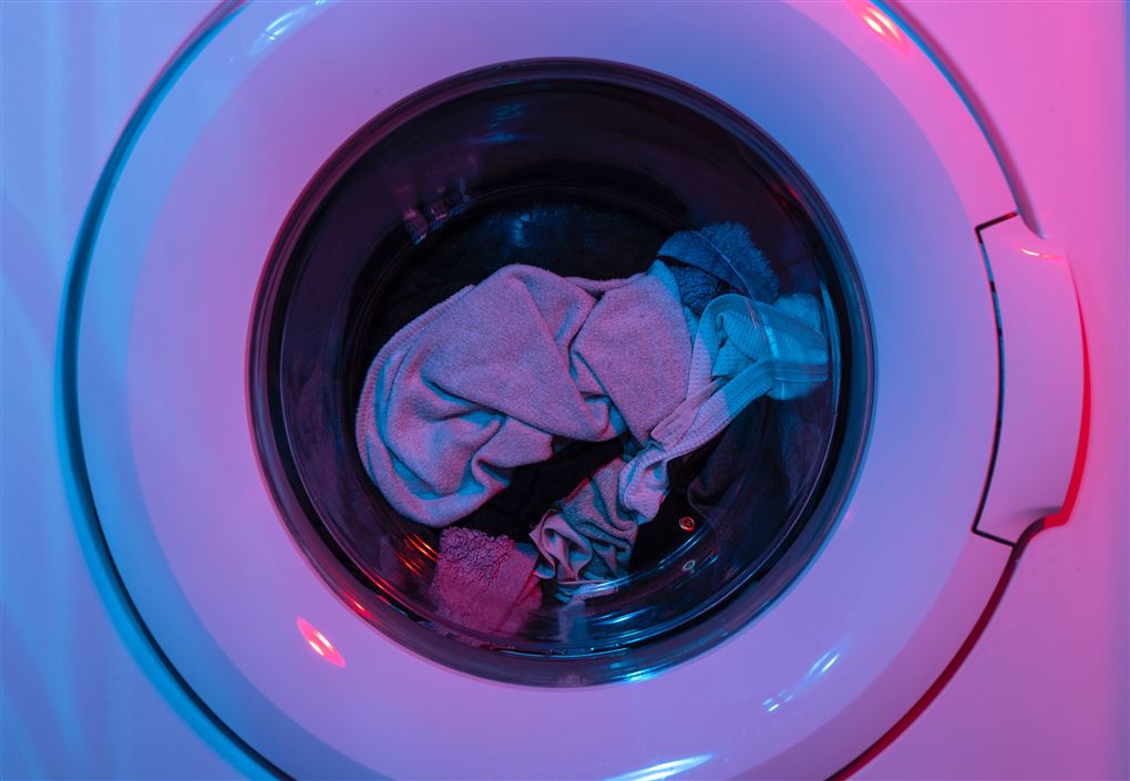 En vaskemaskine med tøj i