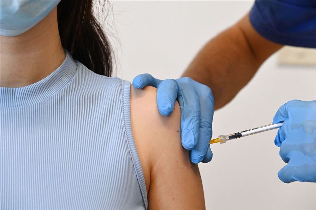 kvinde får vaccination med et stik i skulderen