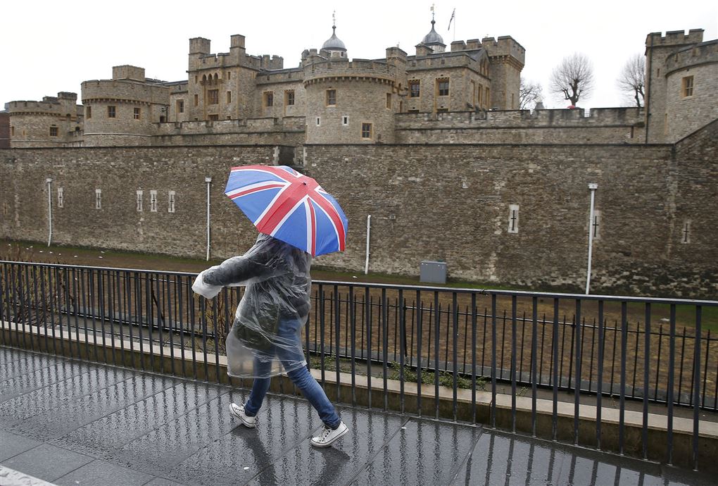 En enlig turist med paraply foran Windsor