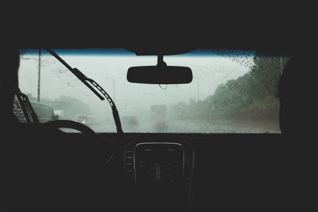 en kørende bil indefra i regnvejr. 