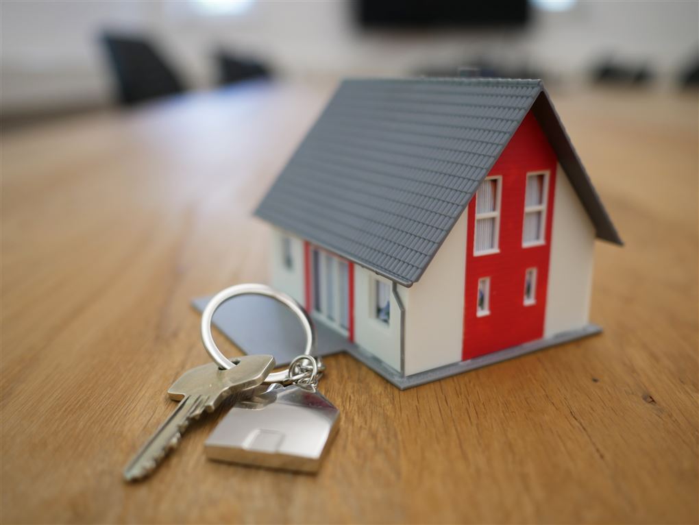 En nøgle ved siden af en lillebitte hus