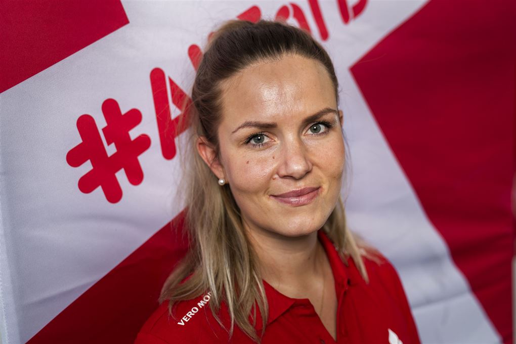 Anna Kasprzak portræt hun har rødt tøj på og står foran et dansk flag