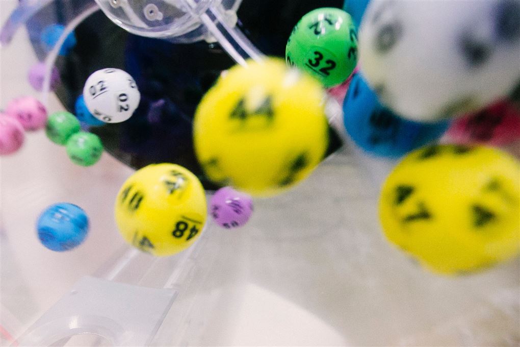 Lotto kugler i forskellige farver med forskellige numre. Kuglerne er i bevægelse. 