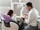 En patient i stolen ved siden af en tandlæge