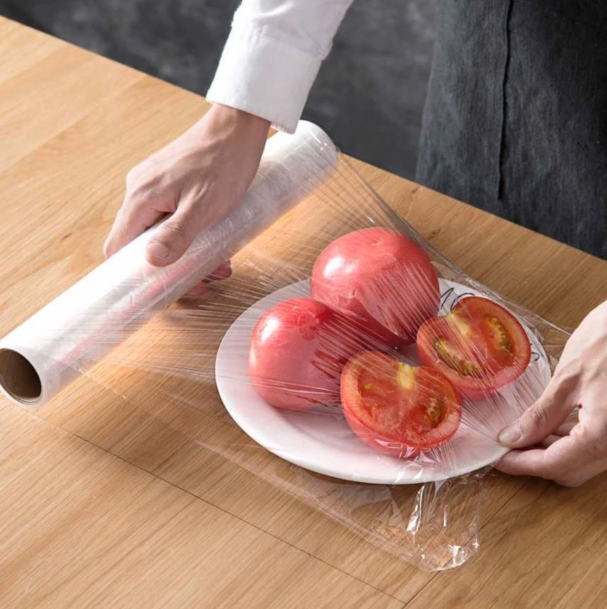 en mand pakker tomater ind i wrap