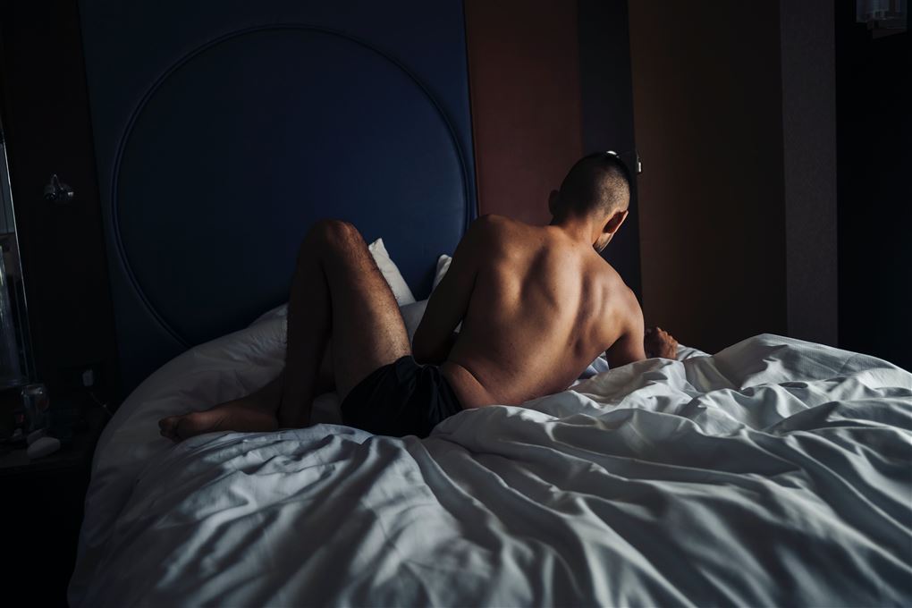 En nøgen mand i en seng