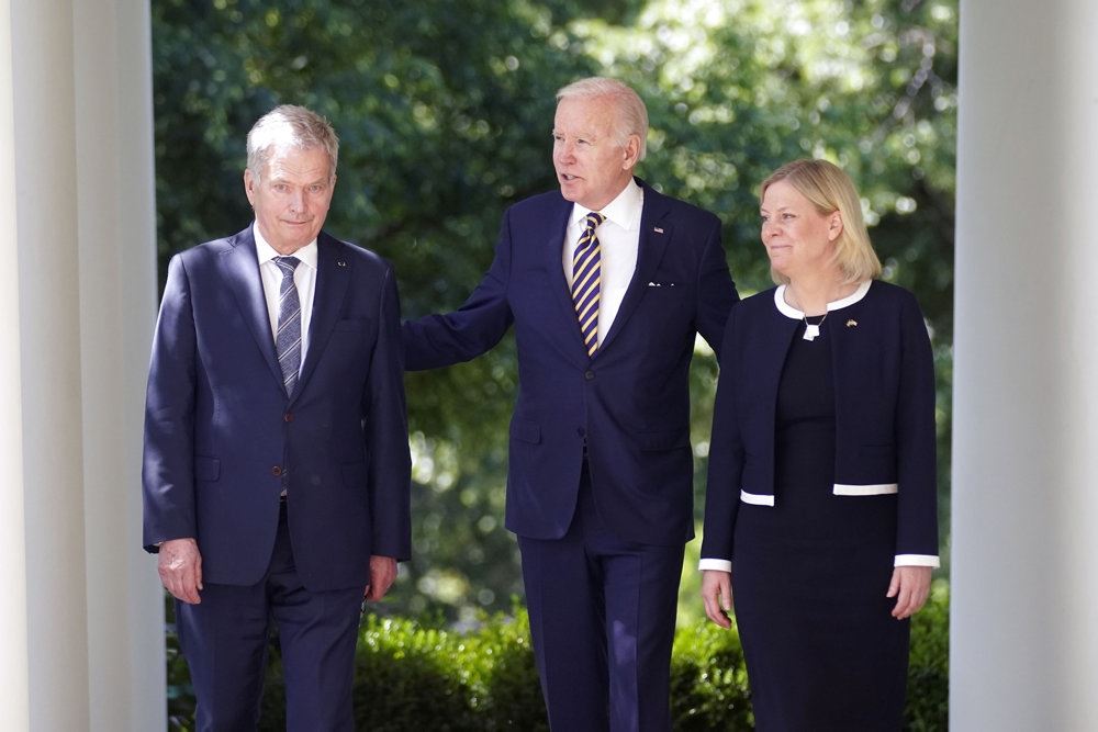 Præsident Biden med to folk i pænt tøj - en kvinde og en mand