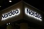 Nordeas logo lyser op i mørke på en bygning