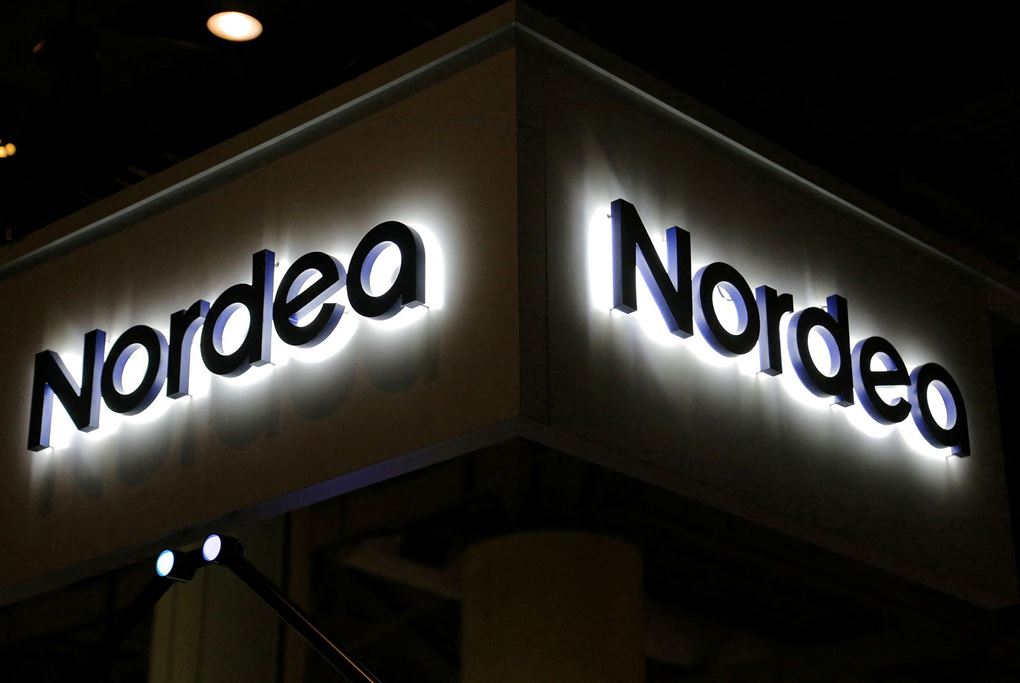 Nordeas logo lyser op i mørke på en bygning