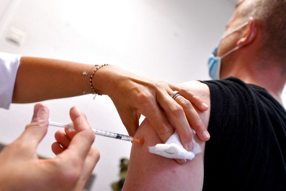 En mand får en vaccine i overarmen. 