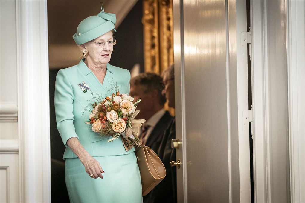 Dronning Margrethe i mintfarvet spadserdragt og en buket blomster i hånden