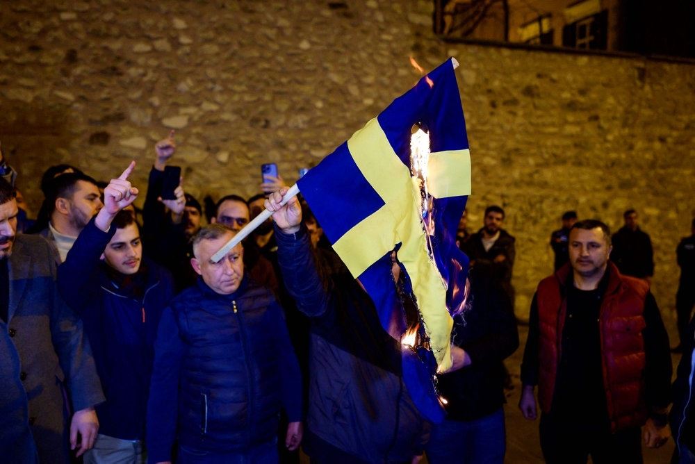 folk med brændende svensk flag