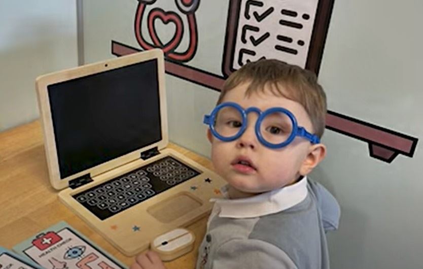 dreng med briller sidder ved computer