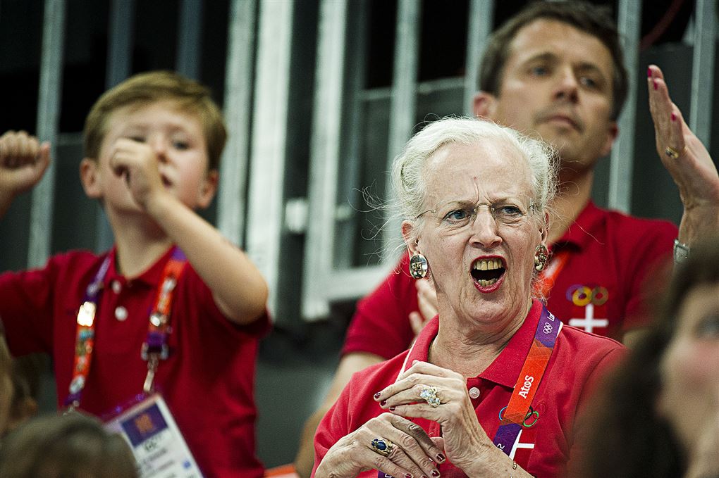 Dronning Margrethe råber fra tilskuerrækkerne. Hun er iført en knaldrød t-shirt.