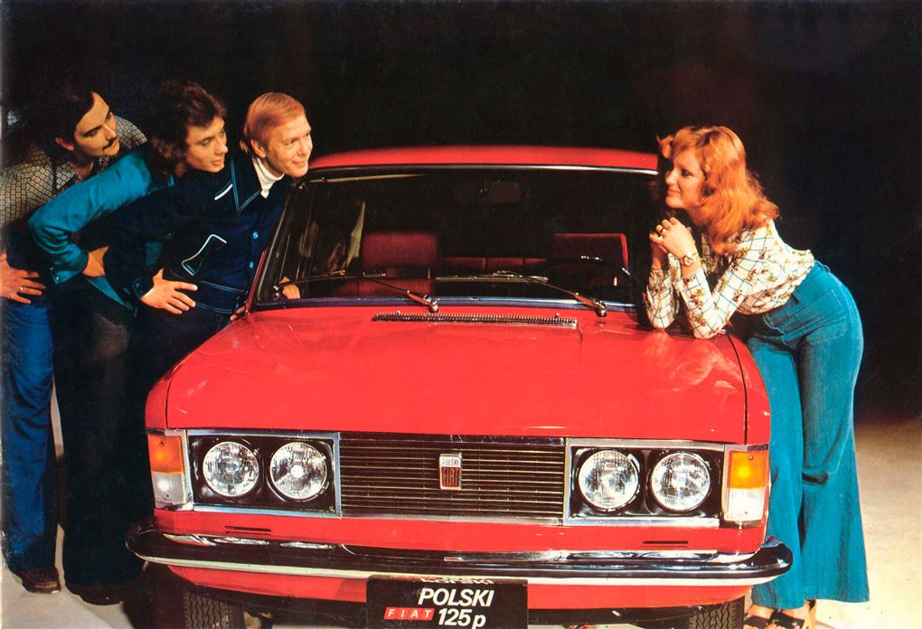 en dame og en rød bil og tre mænd