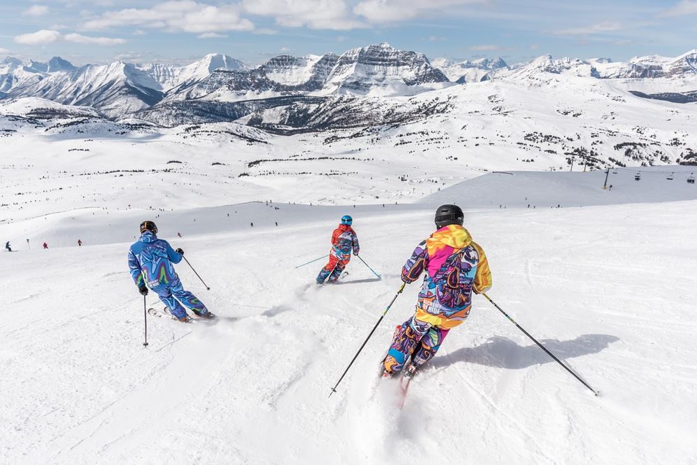 tre personer står på ski