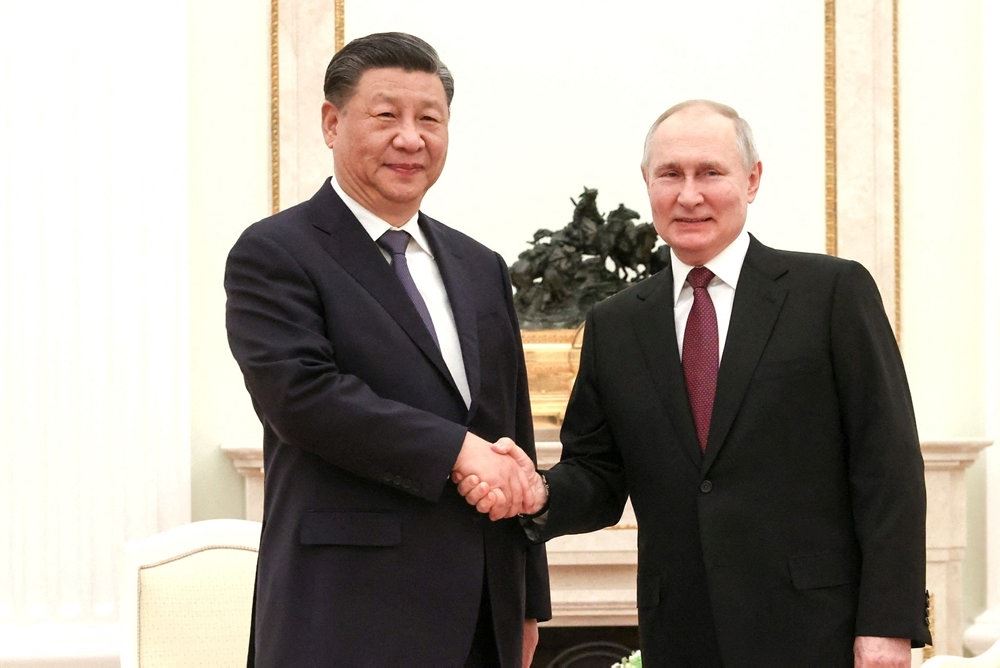 Vladimir Putin trykker hånd med Xi Jinping.