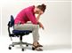 En kvinde med hovedpine sidder på en stol