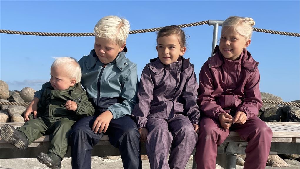 fire børn sidder sammen i solen