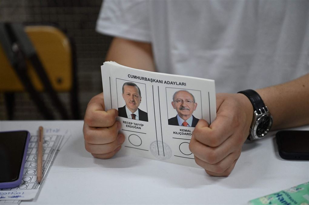 En person holder et valgkort mellem hænderne