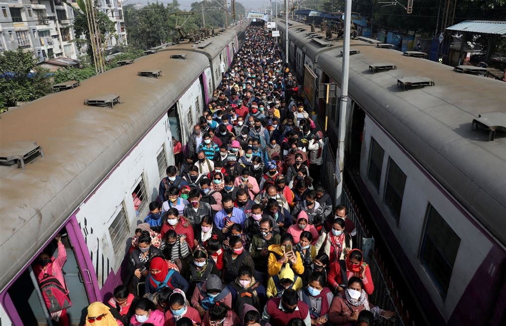 masser af mennesker ved to tog i Indien