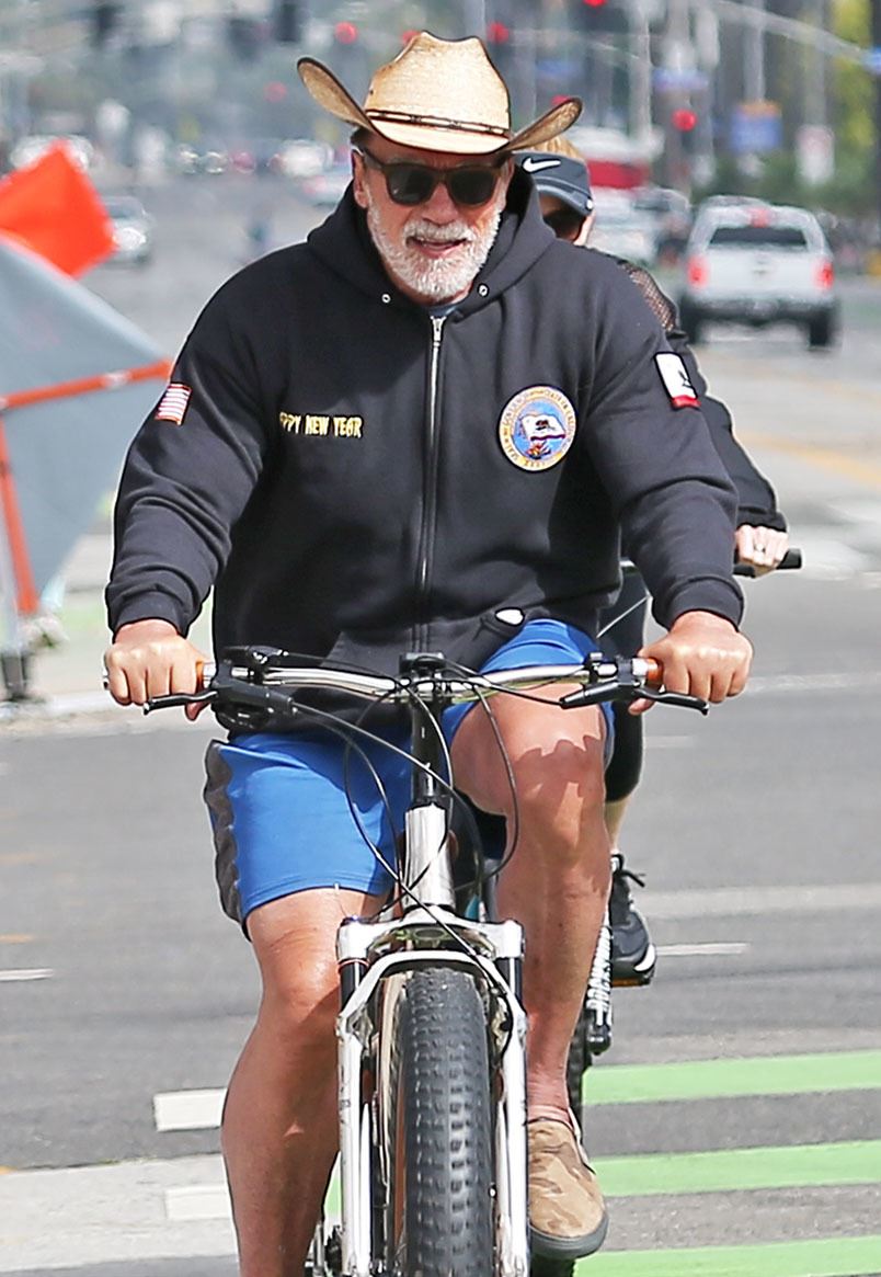 En mand med stråhat på cykel, der smiler