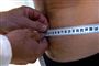 Mand får målt sin mave med et centimeterbånd