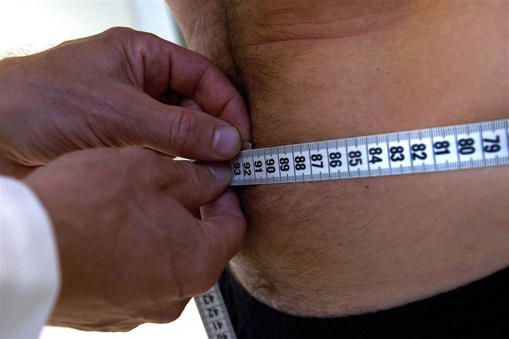 Mand får målt sin mave med et centimeterbånd
