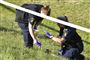 To politbetjente afsøger noget græs