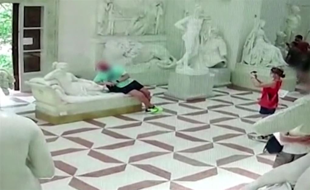 En turist slænger sig på en statue på et museum i Italien