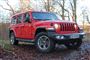 En stor rød Jeep i skoven